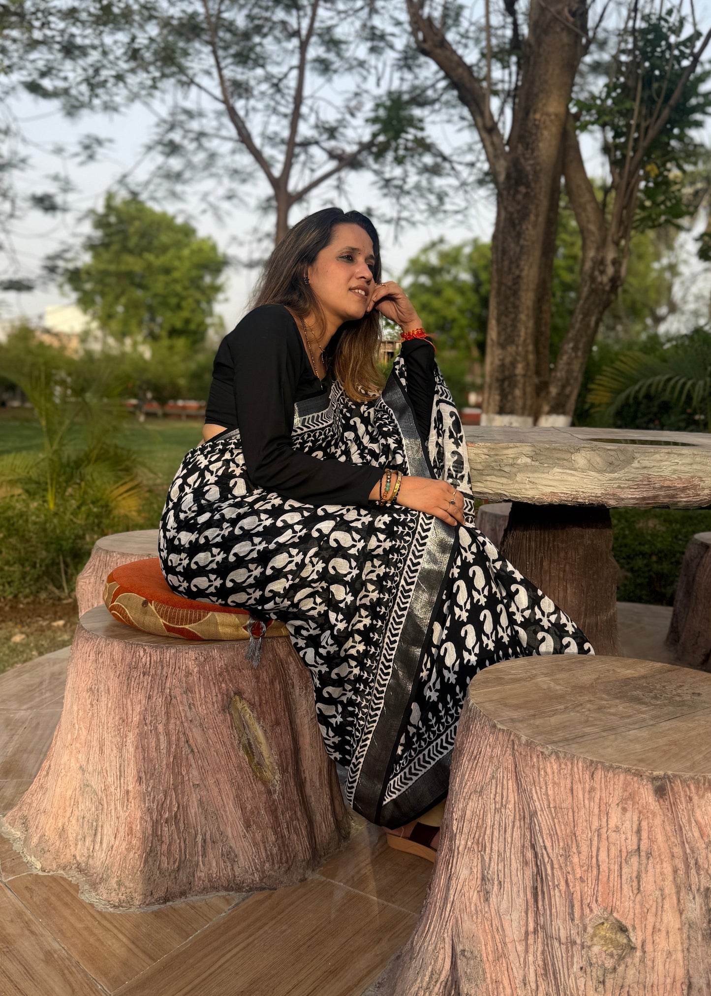 Woman sitting on a tree stump in a park-like setting