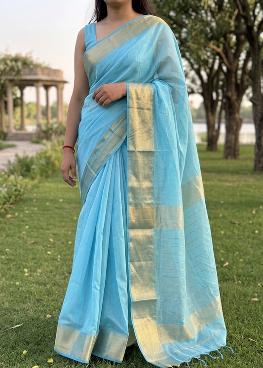 Woman wearing a light blue saree with a blurred outdoor background