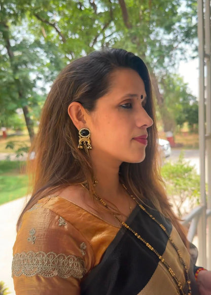 Woman wearing a traditional saree with a blurred outdoor background
