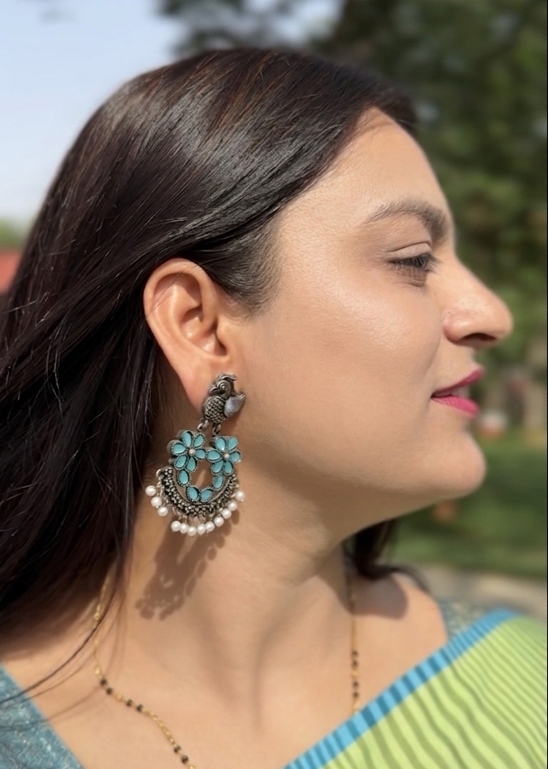 Woman wearing a large turquoise earring outdoors