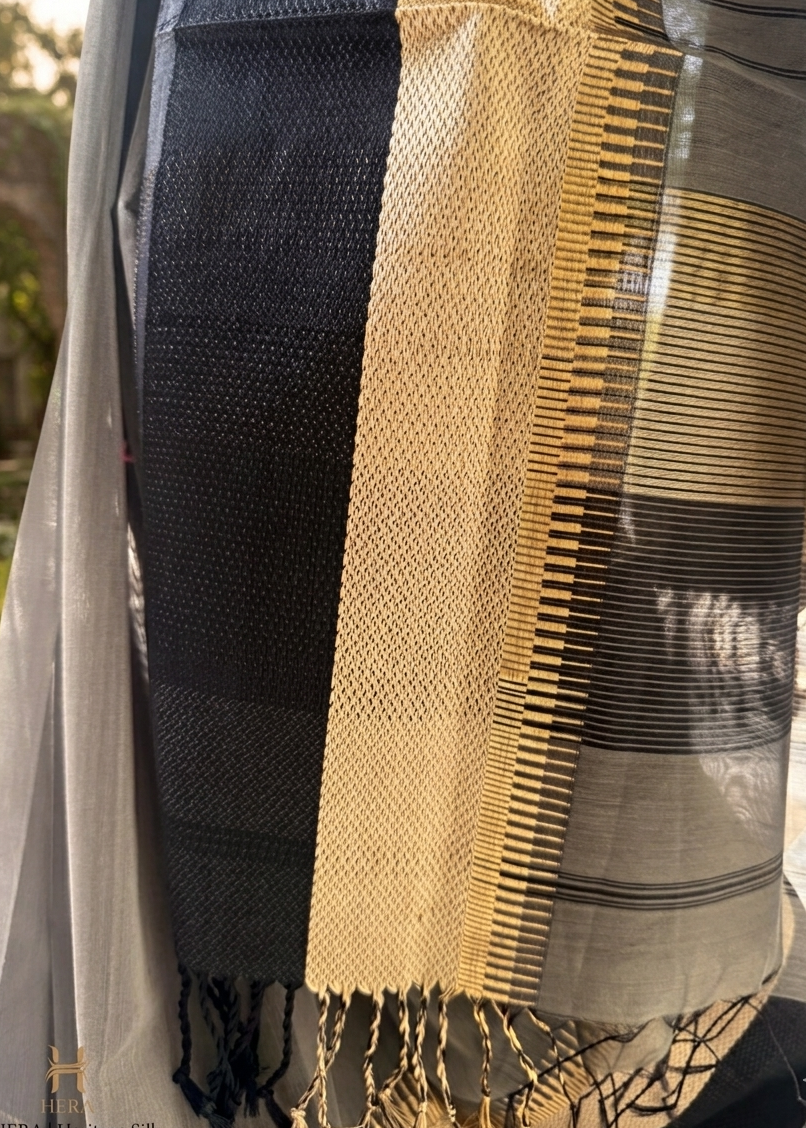 Close-up of a black, beige, and gray striped fabric with tassels.