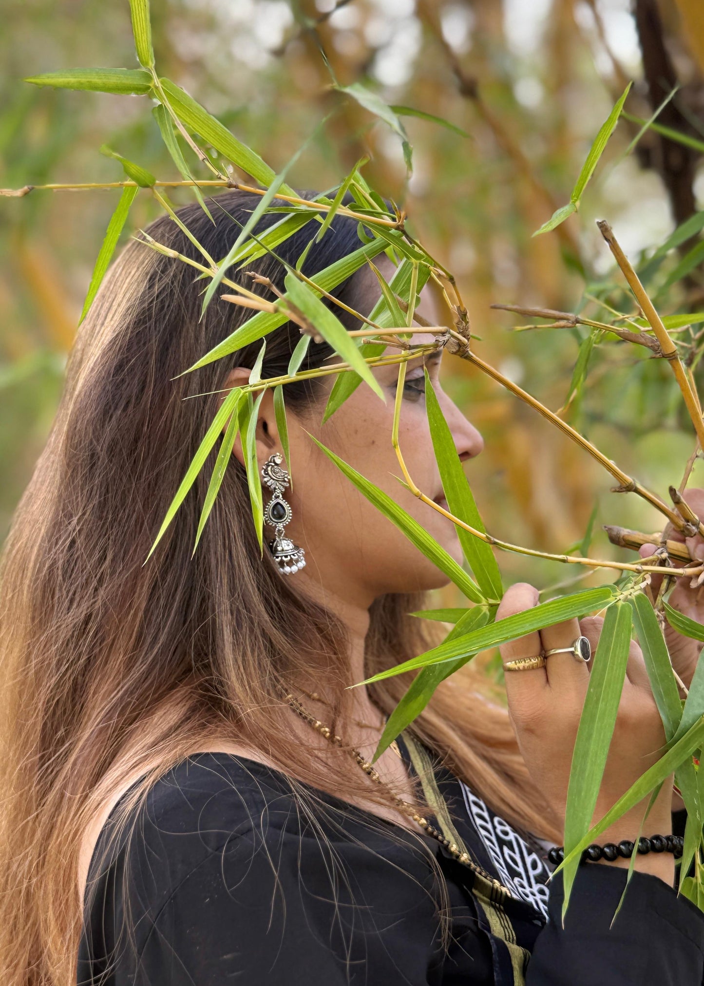 Woman interacting with bamboo leaves in a natural setting